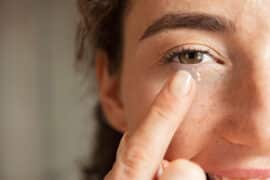 Woman inserting contact lens